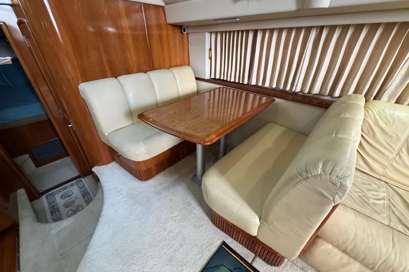  Yacht Photos Pics 2004 Carver 444 Cockpit Motor Yacht interior with beige seating and wooden table.