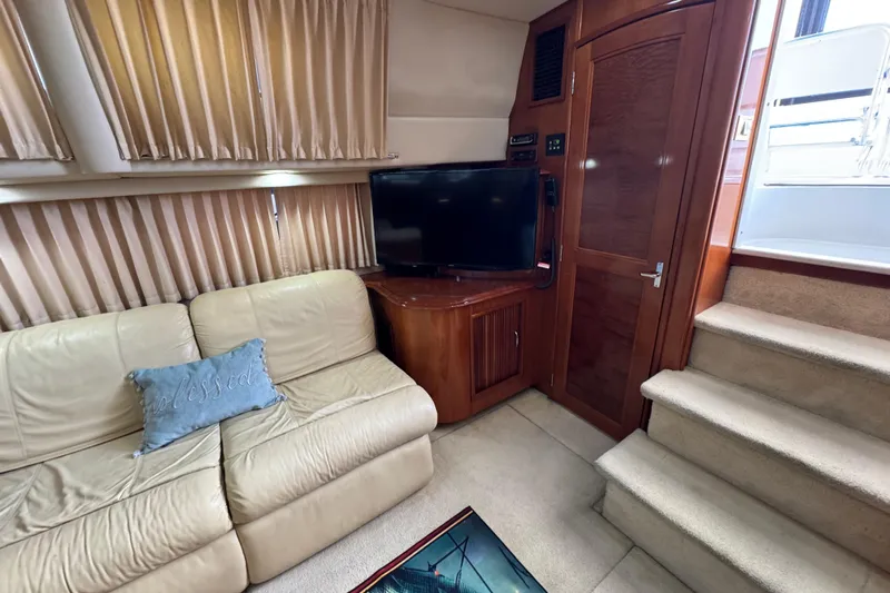  Yacht Photos Pics Interior of 2004 Carver 444 Cockpit Motor Yacht with beige sofa, TV, and stairs.