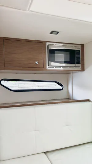  Yacht Photos Pics 2014 Cruisers Sport Series 328 Bow Rider interior with microwave and wood cabinetry.