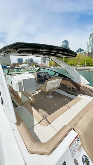  Yacht Photos Pics 2014 Cruisers Sport Series 328 Bow Rider on water, city skyline in background.