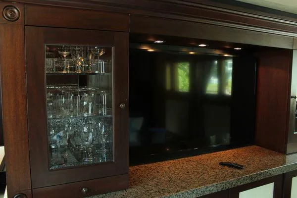  Yacht Photos Pics Luxurious interior of 1983 Cheoy Lee 90 cockpit motor yacht with glass cabinet and TV.