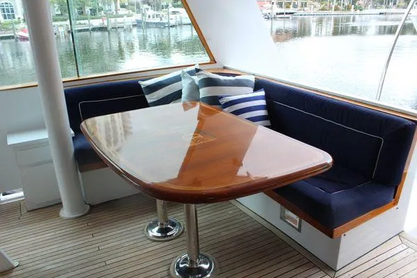  Yacht Photos Pics Elegant dining area on 1983 Cheoy Lee 90 cockpit motor yacht with polished wood table.
