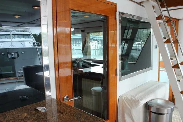  Yacht Photos Pics Interior view of 1983 Cheoy Lee 90 cockpit motor yacht with wooden accents and modern amenities.
