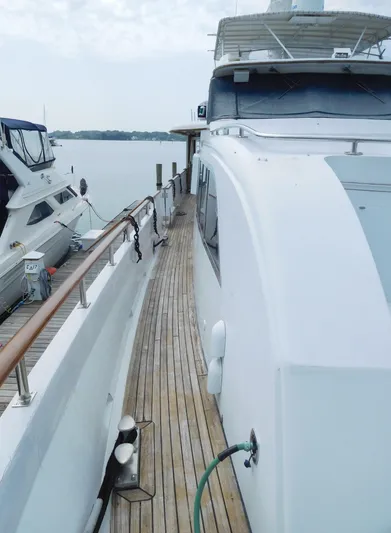  Yacht Photos Pics 1983 Cheoy Lee 90 cockpit motor yacht docked, showcasing sleek design and wooden deck.