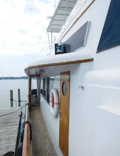  Yacht Photos Pics 1983 Cheoy Lee 90 cockpit motor yacht docked, side view with wooden accents.