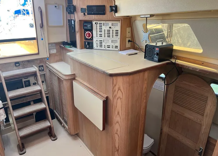  Yacht Photos Pics Interior of 1998 Island Packet Cat 35 sailboat with wooden cabinetry and navigation equipment.
