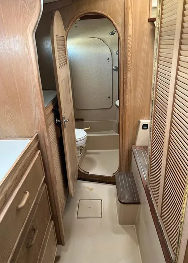  Yacht Photos Pics 1998 Island Packet Cat 35 yacht interior with wooden cabinetry and compact bathroom.