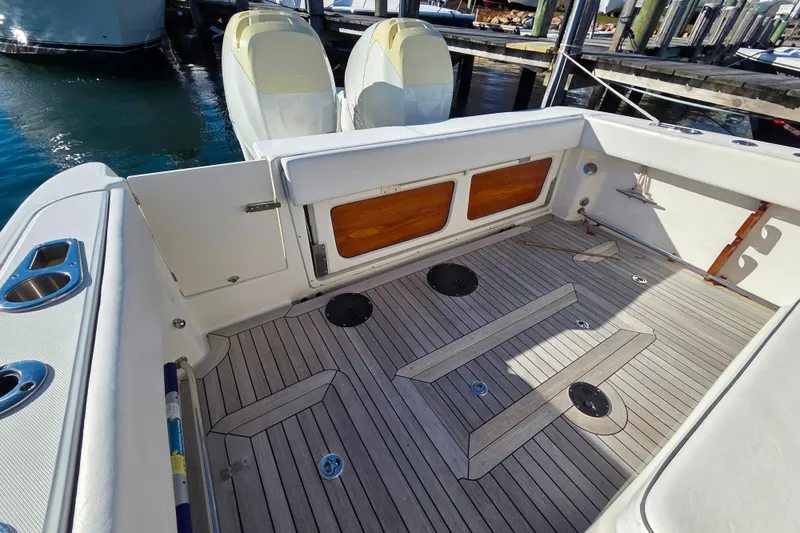  Yacht Photos Pics 2013 Boston Whaler 320 Outrage boat deck with wooden flooring and storage compartments.