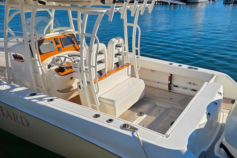  Yacht Photos Pics 2013 Boston Whaler 320 Outrage boat interior with helm and seating, docked on calm water.