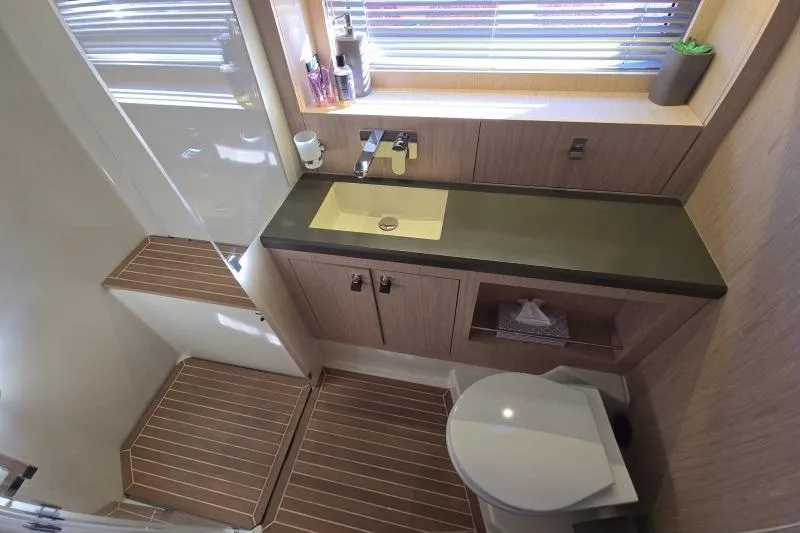 Petit Miracle 2 Yacht Photos Pics Luxurious bathroom in 2018 Beneteau Oceanis Yacht 62, featuring modern fixtures and wooden accents.