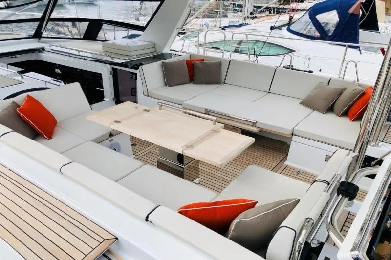 Petit Miracle 2 Yacht Photos Pics Luxurious seating area on 2018 Beneteau Oceanis Yacht 62 with cushions and table.