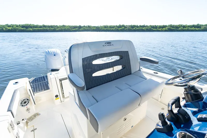  Yacht Photos Pics Manufacturer Provided Image: 2026 Cobia 245 Center Console boat interior with seating and steering wheel on calm water.