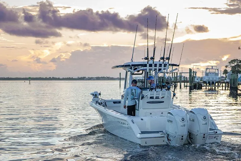  Yacht Photos Pics Manufacturer Provided Image: 2026 Cobia 245 Center Console boat on water at sunset with fishing rods.