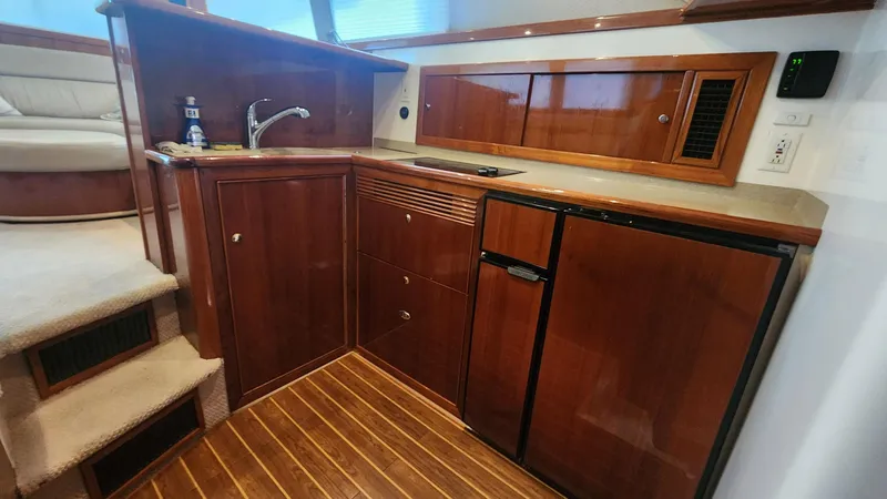 La Marce Yacht Photos Pics Interior of 2002 Riviera 40 Flybridge yacht with wooden cabinetry and compact kitchen area.