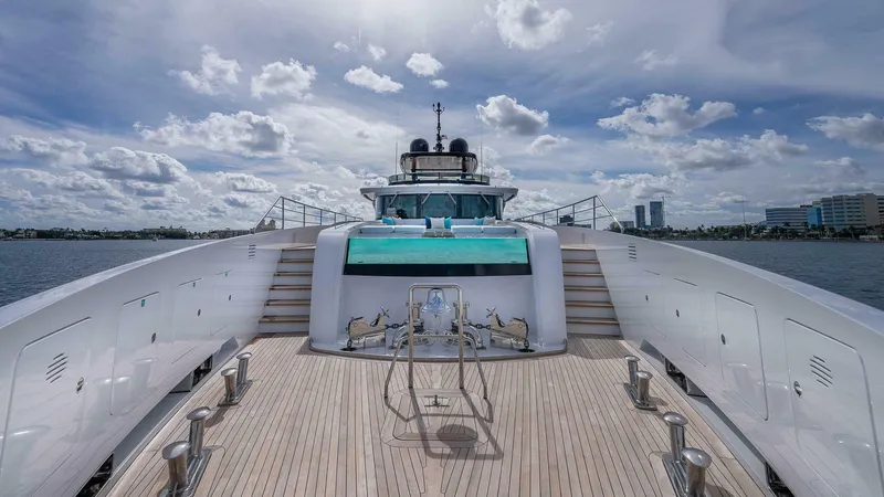 Neverland Yacht Photos Pics Luxurious 2016 Mangusta Oceano 42 yacht deck with pool, under a partly cloudy sky.