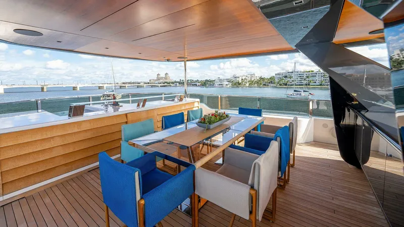 Neverland Yacht Photos Pics Luxury deck of 2016 Mangusta Oceano 42 yacht with elegant dining area and scenic water views.