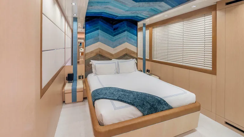 Neverland Yacht Photos Pics Luxurious bedroom interior on 2016 Mangusta Oceano 42 yacht with modern design and blue accents.