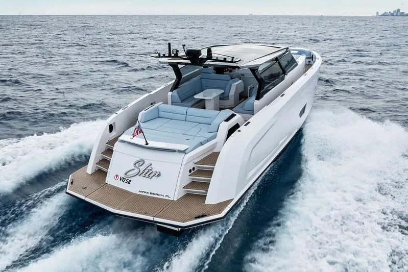 Shir Yacht Photos Pics 2024 Vanquish VQ58 luxury yacht cruising on open sea, rear view.