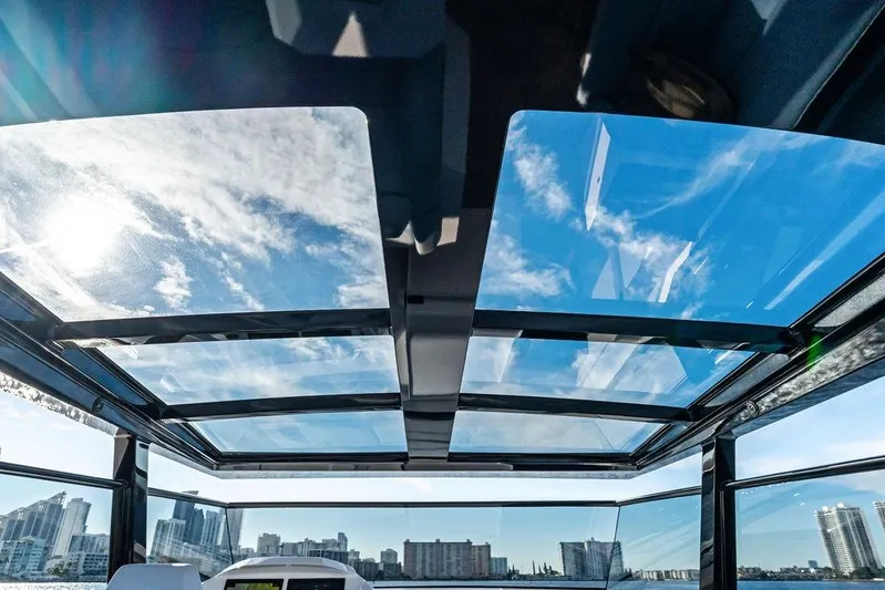 Shir Yacht Photos Pics 2024 Vanquish VQ58 yacht with panoramic glass roof and city skyline view.
