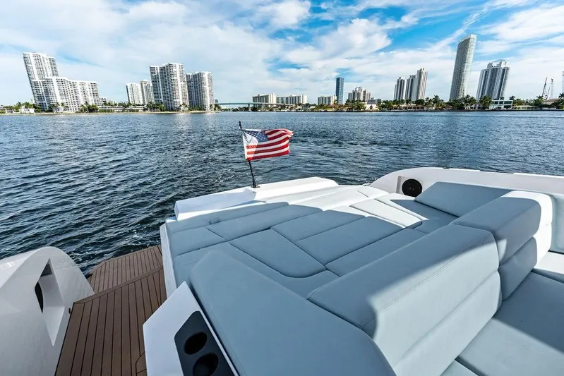 Shir Yacht Photos Pics Luxurious 2024 Vanquish VQ58 yacht with city skyline and American flag.
