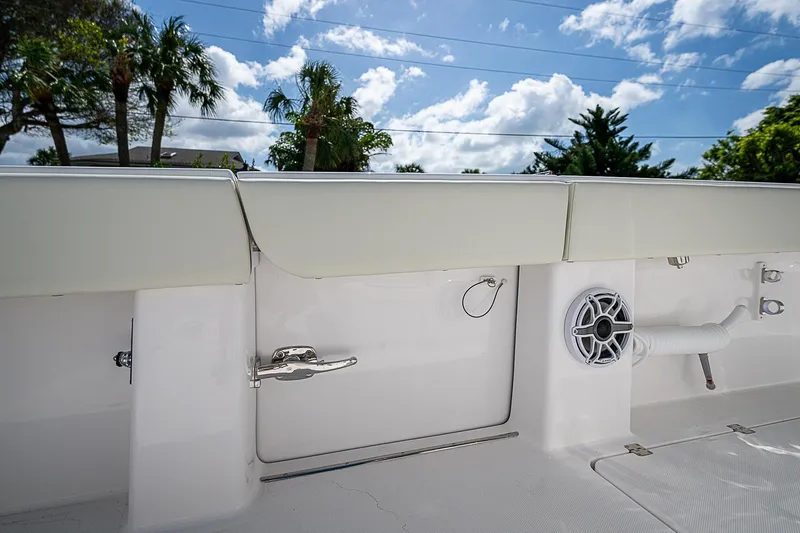  Yacht Photos Pics 2025 Invincible 38 Catamaran deck with storage compartment and speaker, under a blue sky.