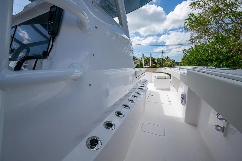  Yacht Photos Pics 2025 Invincible 38 Catamaran deck with rod holders and seating under a blue sky.