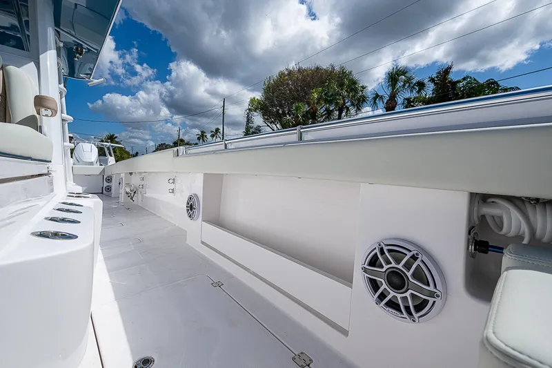  Yacht Photos Pics 2025 Invincible 38 Catamaran deck with speakers and storage under a cloudy sky.