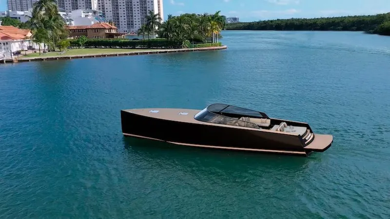  Yacht Photos Pics Luxurious 2025 VanDutch 56 yacht cruising on a serene waterway near modern buildings.