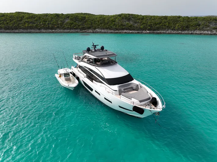 Record Year Yacht Photos Pics 2021 Princess Y85 Motor Yacht anchored in turquoise waters near lush shoreline.