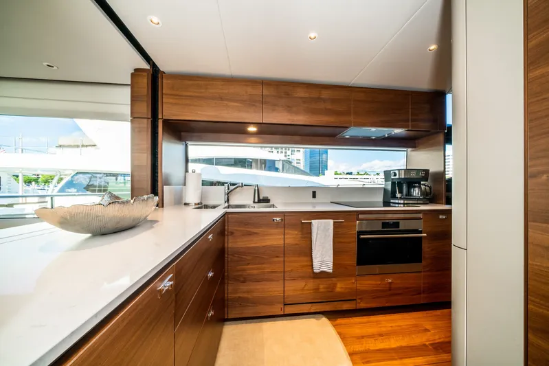 Record Year Yacht Photos Pics Luxurious kitchen interior of 2021 Princess Y85 Motor Yacht with modern appliances and wood cabinetry.