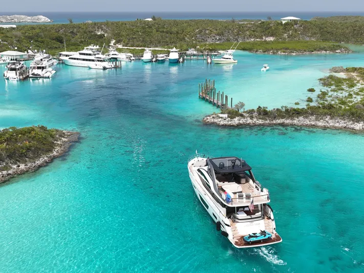 Record Year Yacht Photos Pics Luxurious 2021 Princess Y85 Motor Yacht cruising in turquoise waters near a marina.