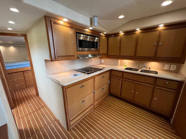 Pacific Adventures Yacht Photos Pics Luxurious 2008 Cabo 52 Express yacht kitchen with wood cabinetry and modern appliances.