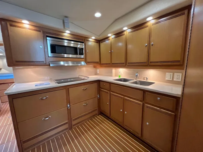 Pacific Adventures Yacht Photos Pics Luxurious 2008 Cabo 52 Express yacht kitchen with wood cabinets and modern appliances.