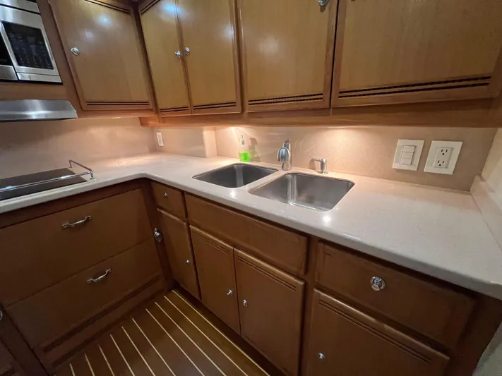 Pacific Adventures Yacht Photos Pics 2008 Cabo 52 Express yacht kitchen with dual sinks and wooden cabinetry.