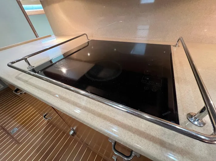 Pacific Adventures Yacht Photos Pics Stovetop on 2008 Cabo 52 Express yacht with sleek countertop and safety rail.