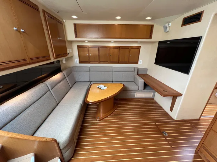 Pacific Adventures Yacht Photos Pics Luxurious 2008 Cabo 52 Express yacht interior with wood flooring and cozy seating area.