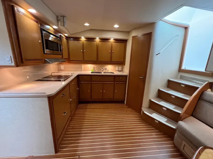 Pacific Adventures Yacht Photos Pics Luxurious 2008 Cabo 52 Express yacht interior with modern kitchen and wooden flooring.