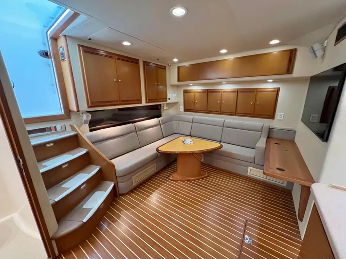 Pacific Adventures Yacht Photos Pics Luxurious interior of 2008 Cabo 52 Express yacht with wood flooring and plush seating.