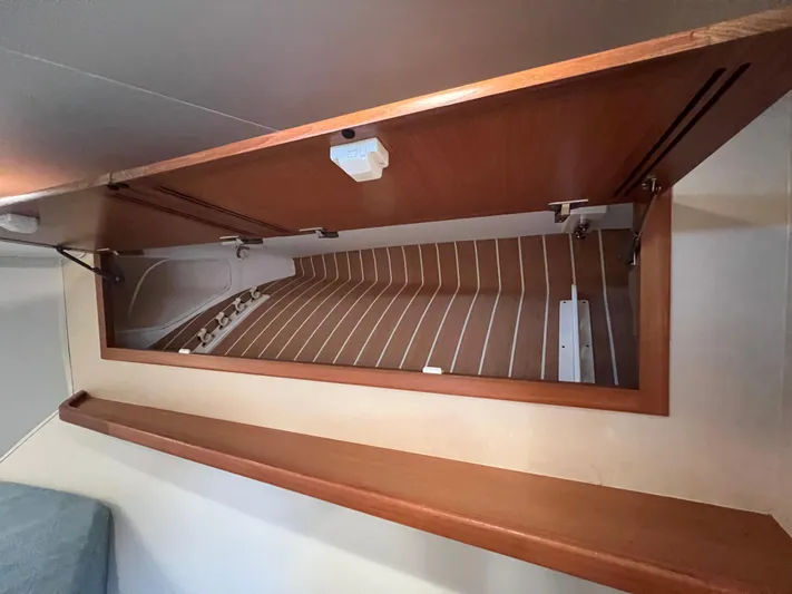 Pacific Adventures Yacht Photos Pics 2008 Cabo 52 Express interior storage compartment with wooden finish.