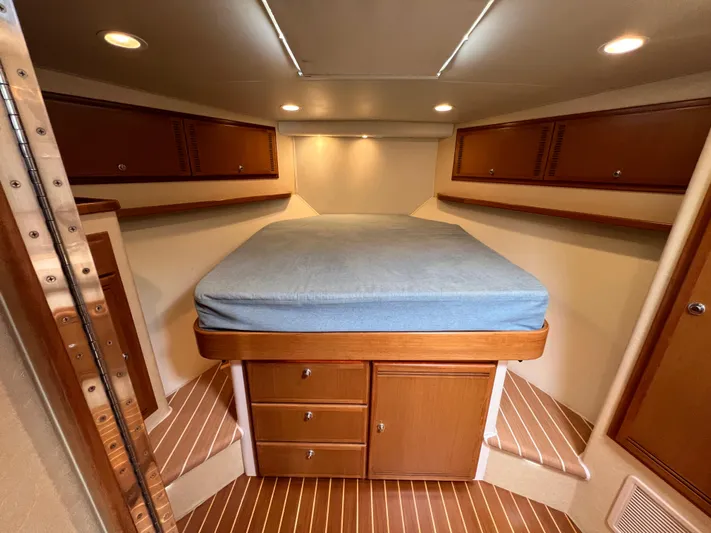 Pacific Adventures Yacht Photos Pics 2008 Cabo 52 Express cabin with bed, wooden cabinets, and ambient lighting.