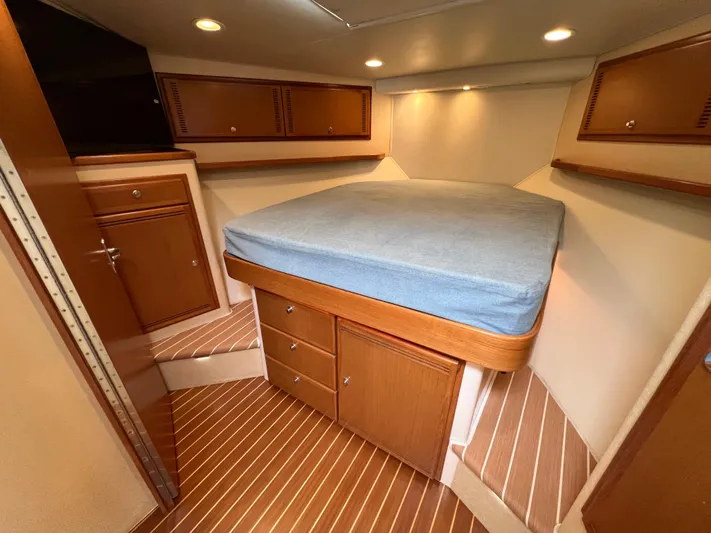 Pacific Adventures Yacht Photos Pics Interior cabin of 2008 Cabo 52 Express yacht with wood finish and cozy bed.