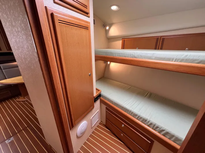 Pacific Adventures Yacht Photos Pics Interior of 2008 Cabo 52 Express yacht with wooden bunk beds and cozy lighting.