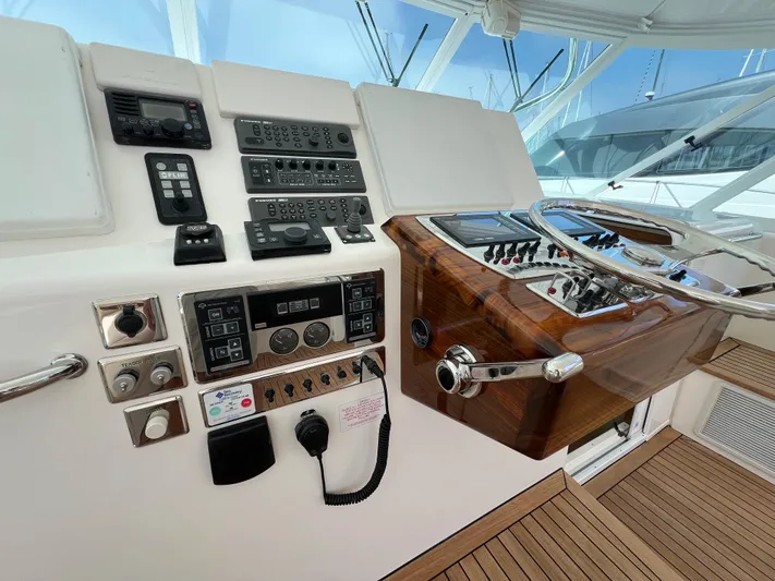 Pacific Adventures Yacht Photos Pics Helm of 2008 Cabo 52 Express yacht with modern controls and wooden accents.