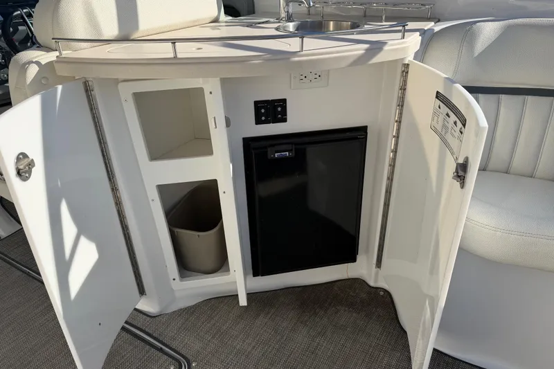  Yacht Photos Pics 2019 Cobalt R35 boat interior with open cabinet, mini fridge, and sink.