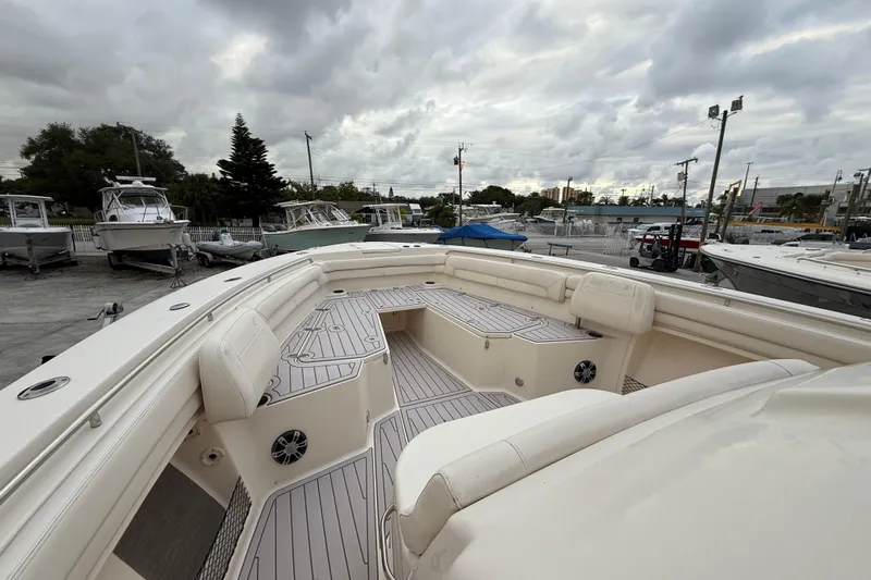 376-420 Brokerage Tyler Yacht Photos Pics 2020 Grady-White Canyon 376 boat interior with cushioned seating and deck, under cloudy sky.