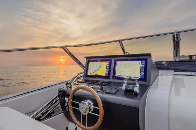  Yacht Photos Pics 2023 Itama 62 RS yacht helm with sunset view, featuring modern navigation displays.