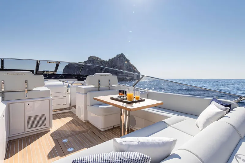  Yacht Photos Pics Luxurious 2023 Itama 62 RS yacht interior with ocean view and refreshments on table.