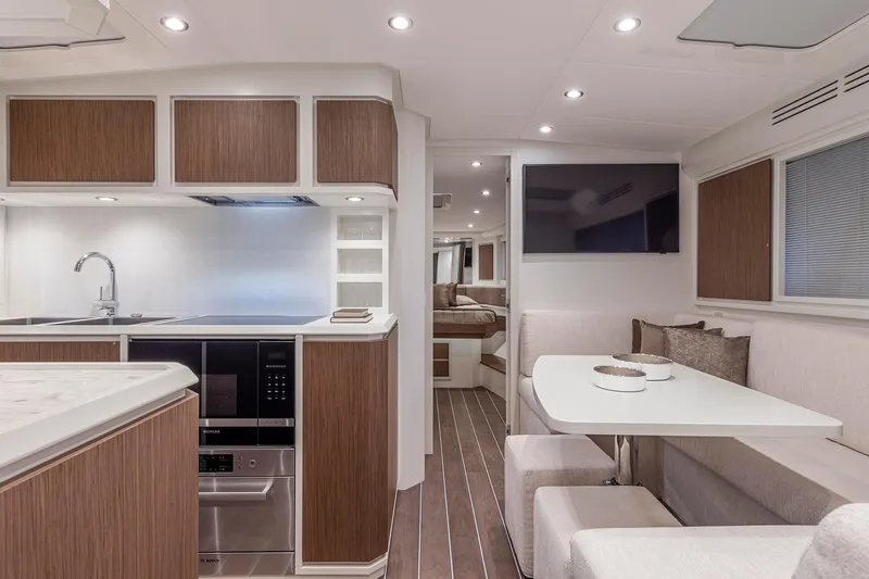  Yacht Photos Pics Luxurious interior of 2023 Itama 62 RS yacht with modern kitchen and dining area.