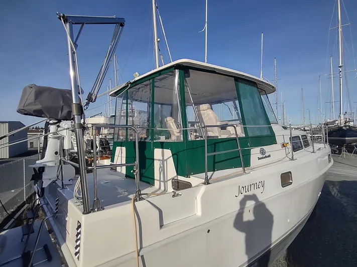 Journey Yacht Photos Pics 2002 Endeavour Trawlercat 36 docked, featuring green canopy and spacious deck.