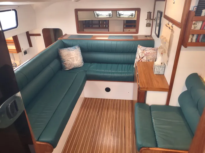 Journey Yacht Photos Pics Interior of 2002 Endeavour Trawlercat 36 with green seating and wooden accents.